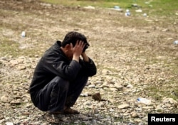 FILE - A father reacts after his son was killed in an airstrike during a battle between Iraqi forces and Islamic State militants, in Mosul, Iraq, March 17, 2017.