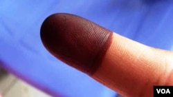 A Cambodian voter displays an ink stained finger after casting his ballot, July 28, 2013. (VOA / Heng Reaksmey)