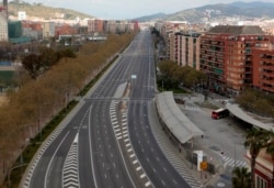 An empty avenue in Barcelona, Spain, Sunday, March 15, 2020. Spain's government announced Saturday that it is placing tight restrictions on movements and closing restaurants and other establishments in the nation. (AP Photo/Joan Mateu)