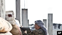 FILE - Kurdish People's Protection Units (YPG) fighters take position at a stronghold in Kobani, Syria.