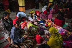 Warga berkumpul di posko pengungsian di Desa Sumber Wuluh di Lumajang pada 5 Desember 2021, pasca erupsi Gunung Semeru yang menewaskan sedikitnya 14 orang. Foto: AFP/Juni Kriswanto)