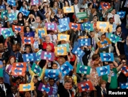 Delegates, including New York Mayor Bill de Blasio, hold Hillary Clinton signs after her nomination at the Democratic National Convention in Philadelphia, July 26, 2016.