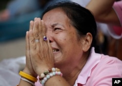 A woman prays for Thailand's King Bhumibol Adulyadej at Siriraj Hospital where the king is being treated in Bangkok, Thailand, Thursday, Oct. 13, 2016.