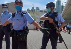 当香港首位被控涉嫌违反国安法的唐英杰坐着轮椅被押解至法院时港警戒备。（2020年7月6日）