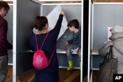 People cast their votes in the Dutch general election in a polling station at the A'dam Tower in Amsterdam, Netherlands, March 15, 2017.