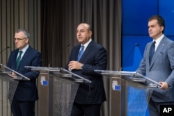 FILE - Turkey's EU Affairs Minister Omer Celik, right, Foreign Minister Mevlut Cavusoglu, center, and Finance Minister Agbal Nihat address the media after an EU Turkey Accession Intergovernmental Conference at the EU Council building in Brussels, June 30, 2016.