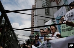 Pro-democracy protesters display black ribbons in front of the Chinese central government's liaison office in Hong Kong, June 17, 2016.