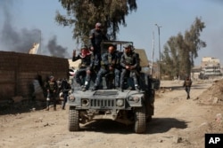 Iraqi security forces advance during fighting against Islamic State militants in western Mosul, Iraq, March 7, 2017.