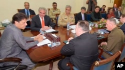 In this photo released by Pakistan's Press Information Department, Pakistan's Prime Minister Imran Khan, left, meets with visiting U.S. Secretary of State Mike Pompeo, front, in Islamabad, Pakistan, Sept. 5, 2018.