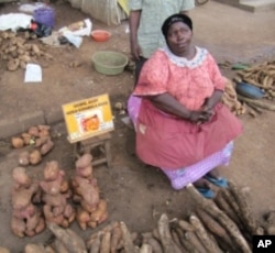 A market vendor in Uganda promotes vitamin A-rich orange sweet potatoes.