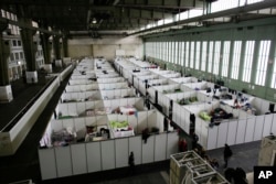 FILE - Cabins are set up inside Hanger 4 of the former airport Tempelhof to be used as a temporary emergency shelter for migrants, refugees and asylum seekers in Berlin, Dec. 9, 2015. The number of migrants entering Germany has dropped significantly in the last few weeks.