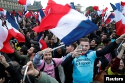 Supporters of French President Elect Emmanuel Macron celebrate near the Louvre museum after early results were announced in the second round vote in the 2017 presidential elections in Paris, France, May 7, 2017.