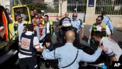 Israeli medics move a Palestinian woman, who police believe attacked a man, at the scene of a stabbing attack in Jerusalem, Nov. 23, 2015.