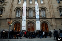FILE - People wait for the opening of a polling station to cast their vote for the Catalan regional election in Barcelona, Spain, Dec. 21, 2017.