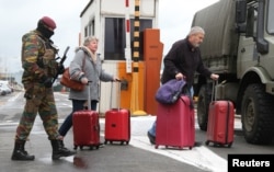 A Belgian soldier accompanies passengers at Brussels' Zaventem airport following Tuesday's bomb attacks in Brussels, March 23, 2016.
