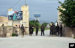 Afghan soldiers stand guard at the gate of a military base in Mazar-i-Sharif, Afghanistan, April 21, 2017, after an attack by Taliban suicide bombers and gunmen who entered the compound wearing Afghan army uniforms.