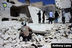Civil Defense members inspect damaged buildings after airstrikes hit the Bustan al-Qasr neighborhood of Aleppo, Syria, Sept. 25, 2016.