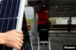 A prisoner places solar panels on the roof of Pingtung prison in Pingtung, Taiwan, Feb. 15, 2017.