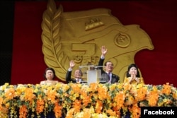 លោក​ស្រី សៅ ទី ​លោក ហេង សំរិន លោក​នាយករដ្ឋមន្ត្រី ហ៊ុន​ សែន និងលោកស្រី ប៊ុន រានី ចូលរួម​ក្នុង​ពិធី​អបអរសាទរ​ថ្ងៃ​ជ័យជម្នះ ៧មករា លើកទី៤០ឆ្នាំ នៅ​ពហុកីឡដ្ឋាន​ជាតិ​អូឡាំពិក។ (រូប​ថត​ពី​ទំព័រ​ហ្វេសប៊ុក Samdech Hun Sen, Cambodian Prime Minister)