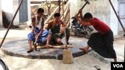 Workers build one of the giant gongs at a workshop in Myanmar that will later go to a temple or monastery. (Z. Aung/VOA)