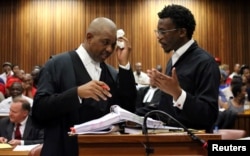 Advocate Dali Mpofu (L) reacts as he chats to Advocate Tembeka Ngcukaitobi during court hearing arguments on a report into allegations of political interference by wealthy friends of President Jacob Zuma, at the North Gauteng High Court, in Pretoria, South Africa. November 2, 2016.