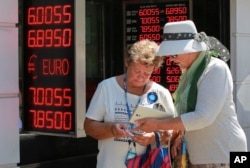 Tourists count their Turkish liras after exchanging foreign currency at a exchange shop in Istanbul, Aug. 13, 2018.