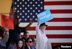FILE - Supporters of Democratic U.S. presidential candidate Hillary Clinton hold up signs as they wait for her to speak at a "Latinos for Hillary" rally in San Antonio, Texas, Oct. 15, 2015.