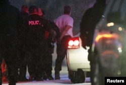 Police put the man suspected of killing at least three people during a shooting at a Planned Parenthood center in Colorado Springs, Colorado into a police vehicle, Nov. 27, 2015.