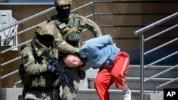 FILE - Bosnian Serb police escort a man suspected of links to Islamic extremists to court in the town of Banja Luka, Bosnia, May 8, 2015.
