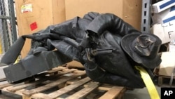 A damaged nearly century-old Confederate statue lies on a pallet in a warehouse in Durham, N.C. on Tuesday, Aug. 15, 2017. It was pulled down by a crowd on Monday night.