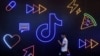 FILE - A man holding a phone walks past a sign of Chinese company ByteDance's app TikTok, in Hangzhou, Zhejiang province, China, Oct. 18, 2019. 
