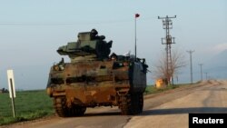 Turkish soldiers ride in an armoured personnel carrier (APC) as they patrol in a village near the Turkish-Syrian border in Hatay province, Turkey, Jan. 28, 2018. 