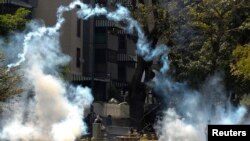 FILE - Anti-government protesters walk through tear gas during riots in Caracas, Apr. 6, 2014. 