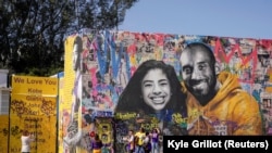 Les fans se rassemblent autour d'une peinture murale de Kobe Bryant et de sa fille Gianna Bryant lors d'un mémorial public pour eux et sept autres personnes tuées dans un accident d'hélicoptère, Californie, le 24 février 2020.