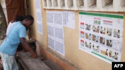 Les électeurs examinent une liste électorale devant un bureau de vote dans le quartier de Be à Lomé le 20 décembre 2018 lors de la procédure de vote pour les élections législatives.