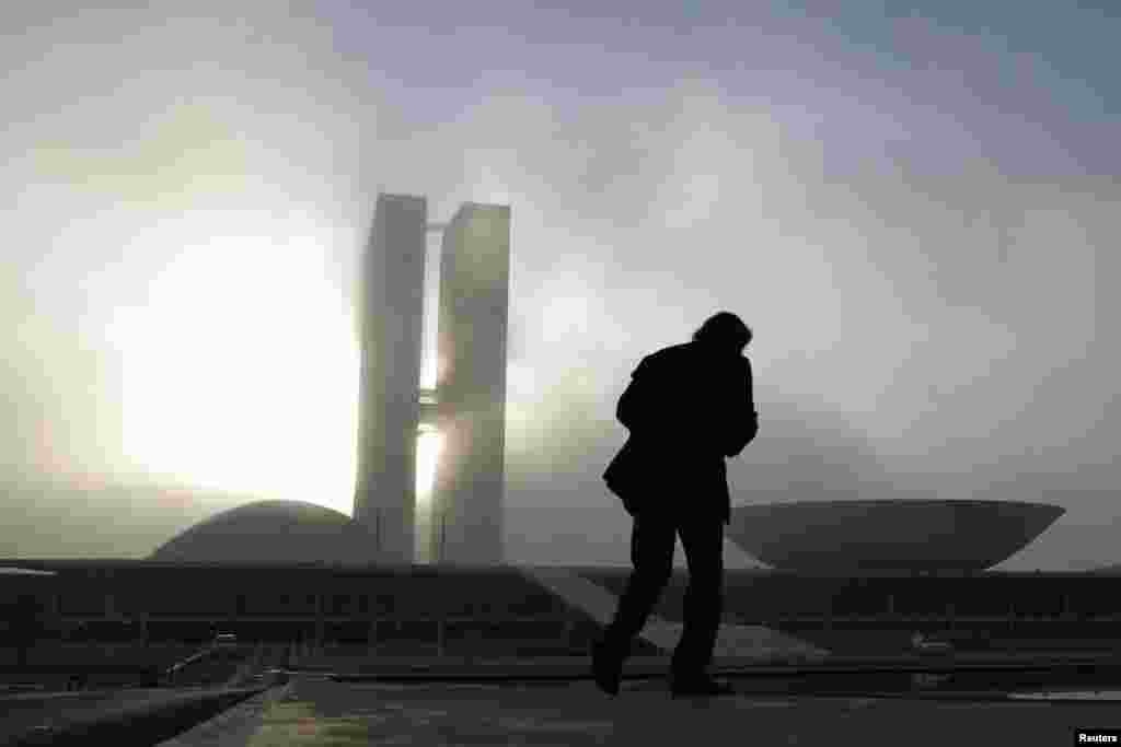 A man walks near the National Congress building, designed by Brazilian architect Oscar Niemeyer, in the Ministries Esplanade in Brasilia, December 6, 2012. 
