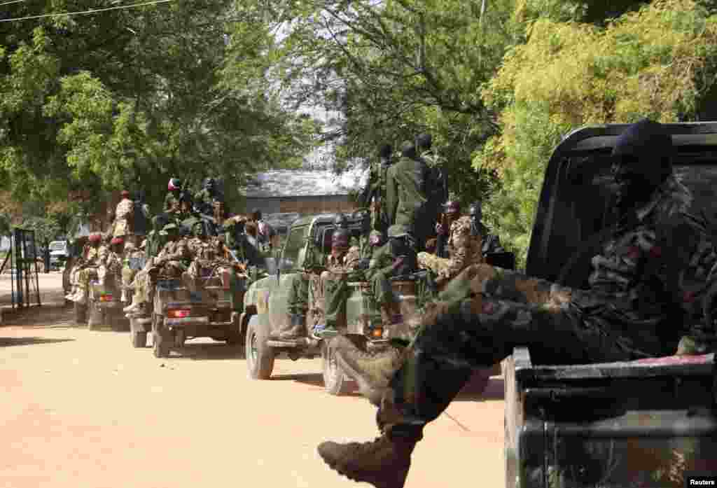 South Sudan army soldiers hold their weapons as they ride on a truck in Bor, Dec. 25, 2013. 
