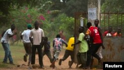 A crowd runs for cover as African Union (AU) peacekeeping soldiers fire warning shots to disperse a crowd near the district of Miskine in Bangui, Feb. 7, 2014. 