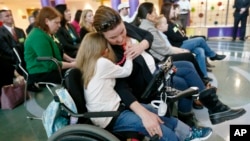 FILE - Abigail Gabriel, 8, hugs her mother, Erin, as a Pennsylvania Department of Human Services official talks about the Children's Health Insurance Program, CHIP, during a news conference, Dec. 7, 2017, in Pittsburgh. Abigail had health care under Medicaid.