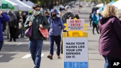 Potrošači s maskama na pijaci u zapadnom Sijetlu , koja se proteklog vikenda otvorila prvi put u poslednja dva meseca (Foto: AP)
