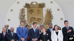 U.N. High Commissioner for Human Rights Michelle Bachelet, third right, poses for a photo with Venezuela's self proclaimed President Juan Guaido, center, and other opposition lawmakers on the steps of the national assembly in Caracas.