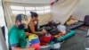 Los migrantes venezolanos se sientan dentro de las carpas instaladas en el Puente Internacional Tienditas en Cúcuta, Colombia, en la frontera con Venezuela, preparadas para los venezolanos que han estado esperando en el Puente Internacional Simón Bolívar, el 16 de junio de 2020.