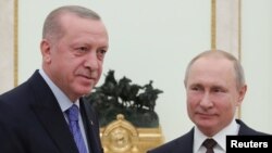 Russian President Vladimir Putin and Turkish President Tayyip Erdogan pose for a photo during a meeting in Moscow, Russia, March 5, 2020. 