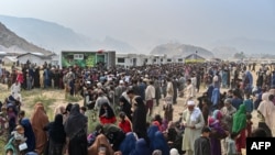 Afghan refugees gather around National Database and Registration Authority vans for biometric verifications as they prepare to depart for Afghanistan, at a holding center in Landi Kotal, Pakistan, on Nov. 1, 2023.