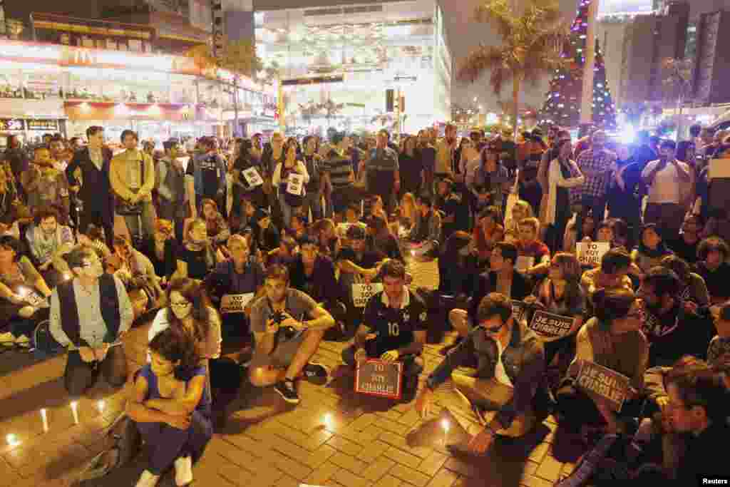 People participate in a vigil to pay tribute to the victims of a shooting at Charlie Hebdo offices at the Kennedy Park in Lima, Peru, Jan. 7, 2015.