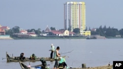 People fish on wooden boats on the Mekong River in Phnom Penh, Aug. 19, 2010. (file photo)