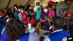 Migran Haiti yang dideportasi dari Texas dan baru tiba di bandara Toussaint Louverture di Port-au-Prince ditemui oleh petugas organisasi migran PBB (IOM) (foto: dok).