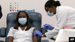 Sandra Lindsay, seorang perawat di Long Island Jewish Medical Center, menerima suntikan vaksin Covid-19 produksi Pfizer-BioNTech di Queens, New York hari Senin (14/12). 