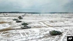 Tanques se mueven durante los ejercicios militares de Bielorrusia y Rusia en un campo bielorruso. [Foto: Prensa del Ministerio de Defensa Ruso vía AP]