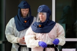 FILE - Salt Lake County Health Department public health nurses look on during coronavirus testing outside the Salt Lake County Health Department in Salt Lake City, October 23, 2020.